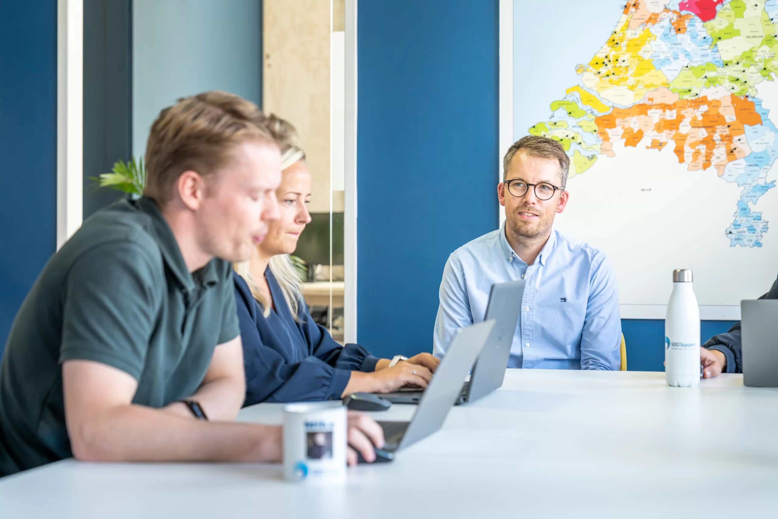 Collega's in vergadering met lach aan tafel op kantoor SDO Support